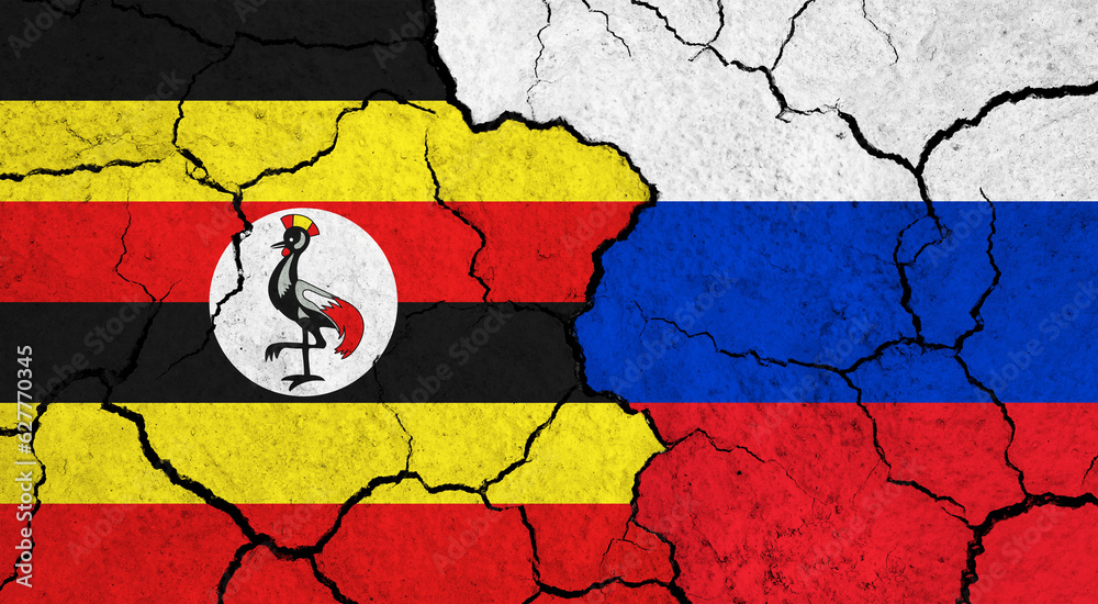 Flags of Uganda and Russia on cracked surface - politics, relationship concept