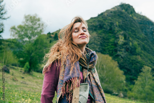 Beautiful woman with long hair enjoying standing in the mountains