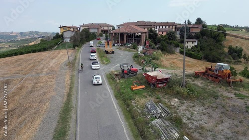 Europe, Italy , Montalto Pavese Oltrepo' - historical antique vintage Fiat cars cross the hills and the wine road - aerial drone view of vintage cars on parade photo