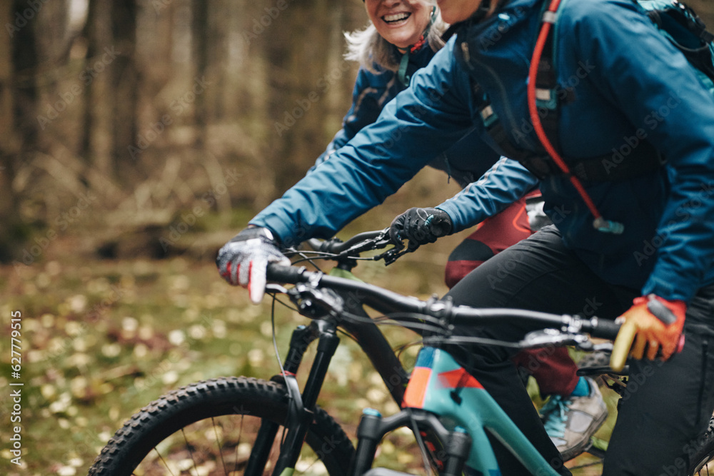 Two mountain bikers riding together on a forest trail Two mountain bikers riding together on a forest trail
