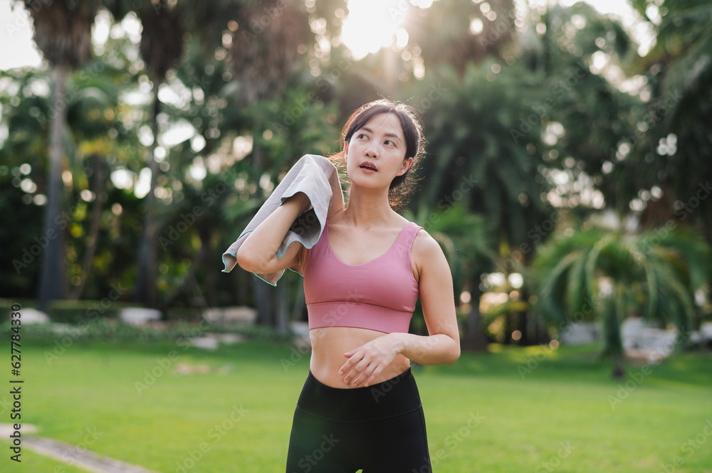 beauty of a healthy lifestyle as a 30s Asian woman in pink sportswear wipes her cheek after a sunset run in the public park. Achieve your fitness goals and embrace a sense of accomplishment. beauty of a healthy lifestyle as a 30s Asian woman in pink sportswear wipes her cheek after a sunset run in the public park. Achieve your fitness goals and embrace a sense of accomplishment.