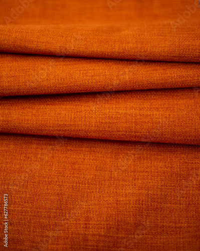 terracotta denim fabric with pleats for background, fabric for garment production close up