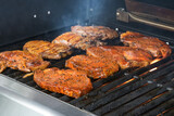 Marinated meat roasting on the barbecue grill for a delicious dinner at a garden party, selected focus