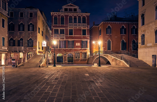 beautiful architecture of Venice, Italy, by night with a little bridge over a canal lit up by streetlight © Ryzhkov Oleksandr