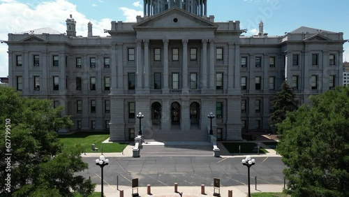 This is a liftoff shot which reveals downtown Denver and the Rocky Mountains from behind the capital building.