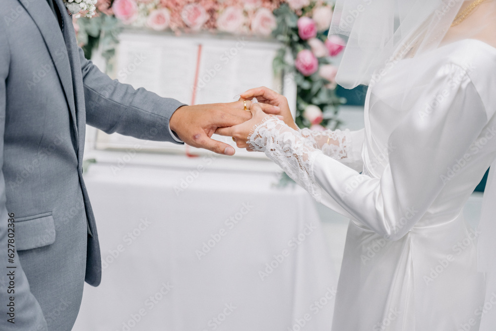 bride and groom holding hands and wear a wedding ring bride and groom holding hands and wear a wedding ring