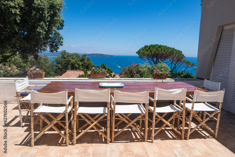 Luxury sea holidays mansion real estate, patio with table and chairs, beautiful sea view, bright summer day