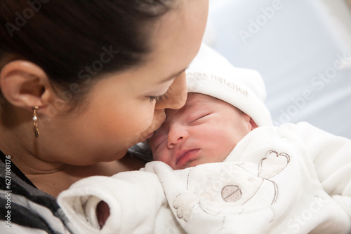 Newborn girl with her mom in the hospital on the day of her birth. Motherhood concept