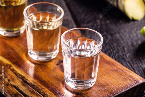 Quadro su tela cups of cachaça, with sugar cane in the background, a Brazilian