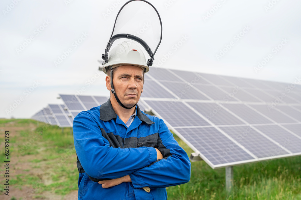 Service Engineer man standing with arms crossed in front of solar panels. Technician maintenance solar cells on Solar Energy Plant under morning sunlight. Technology solar energy renewable Service Engineer man standing with arms crossed in front of solar panels. Technician maintenance solar cells on Solar Energy Plant under morning sunlight. Technology solar energy renewable