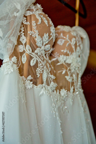 The delicate bride's dress is hanging in room. Selective focus. Close-up.