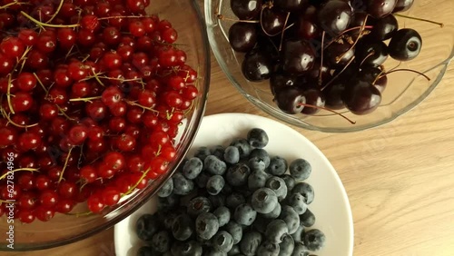 Red currants, cherries and berries on wooden table. Freshly harvested fruits, overhead view