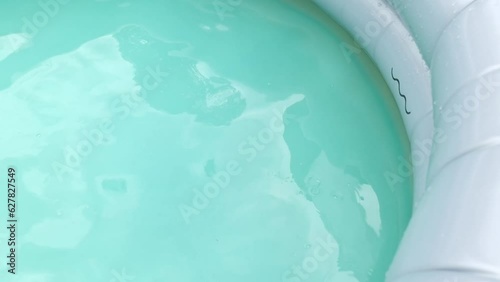 Kids pool with toy ball in the garden, summertime