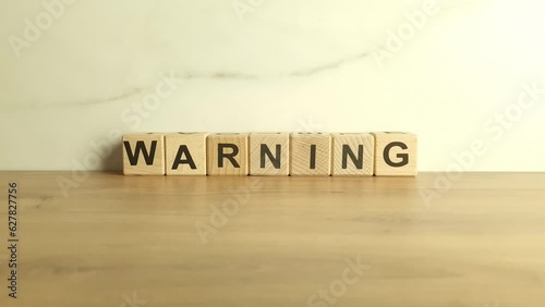 Word warning from wooden blocks. Business and financial risks concept