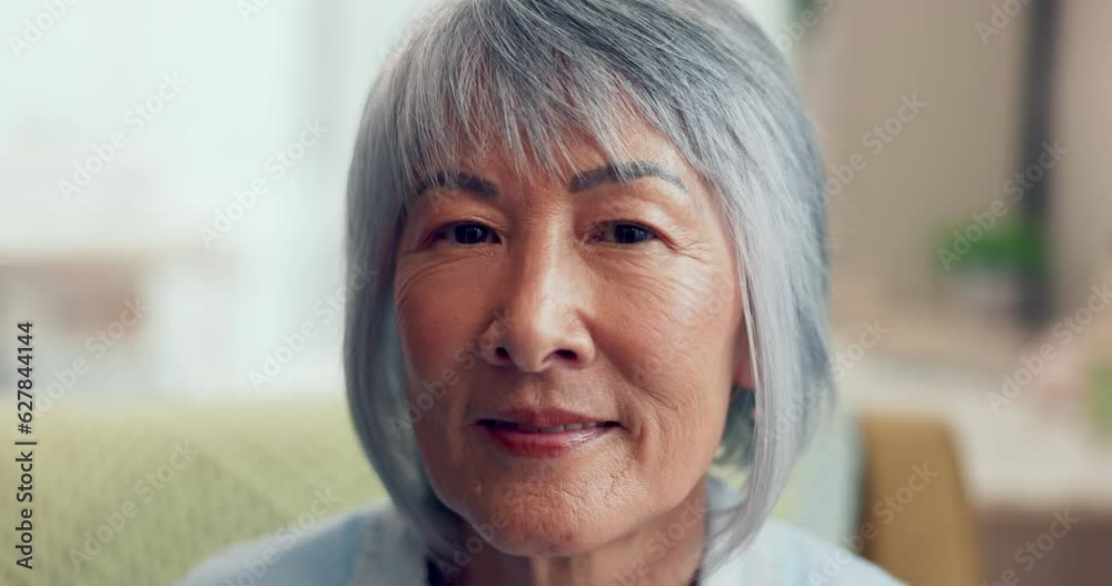 Face, retirement and happy with a senior asian woman in the living room of her home closeup. Portrait, wrinkles and gray hair with an elderly female pensioner sitting in her house to relax alone