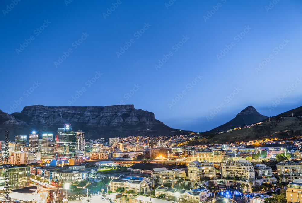 Panorama shot of Cape Town city illuminated buildings with the table mountain and Lion's Head in the background, Cape Town, South Africa
