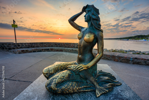 Fototapeta Naklejka Na Ścianę i Meble -  Mermaid statue by the Baltic Sea in Ustka at sunrise. Poland