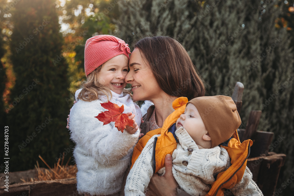 Obraz premium Cheerful family on the farm. Parenting and childhood. Motherhood. Autumn Thanksgiving Day. Outdoor games. Harvesting at farm. Vacation home. Yard decor