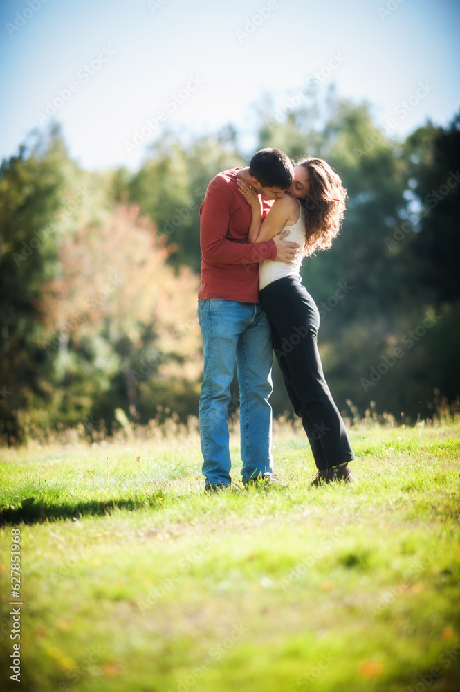 Romantic couple in love hugging and kissing in the park. Relationship and romance concept