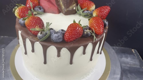 Close up cake with chocolate drips, strawberry and blueberry. Cake with hearts. 4k. Wedding cake.