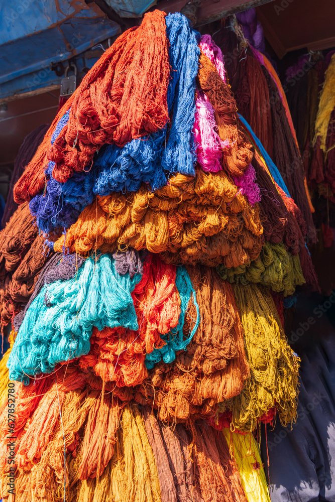 Birghtly colored yarn for sale at a market in Srinagar.