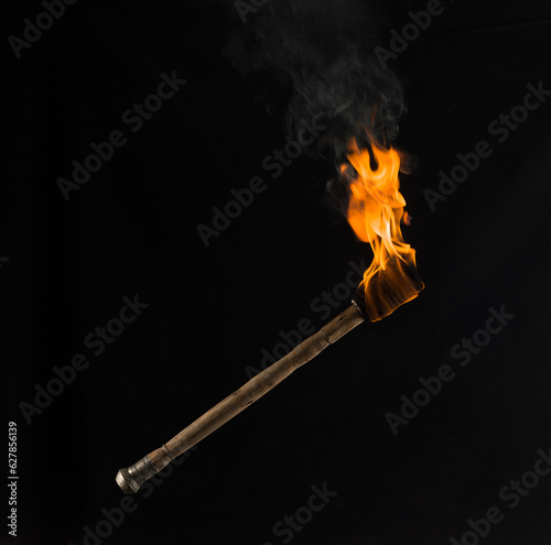 burning wooden torch isolated on black background