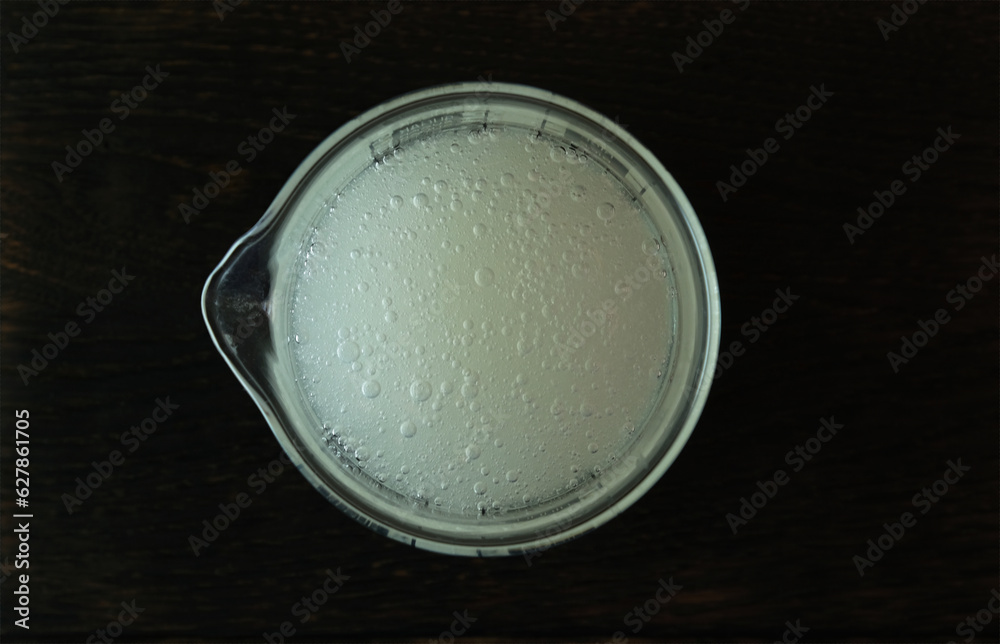 Guar gum liquid in measuring cup, top view. Food additive E412. Guar gum liquid in measuring cup, top view. Food additive E412.