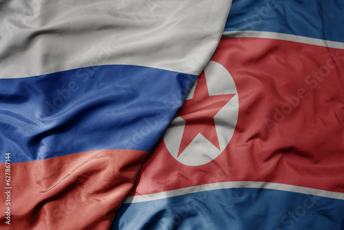 big waving realistic national colorful flag of russia and national flag of north korea . photo