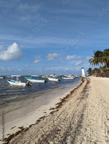 Fototapeta Naklejka Na Ścianę i Meble -  Puerto morelos beach at mexican caribbean, inclined lighthouse and boats
