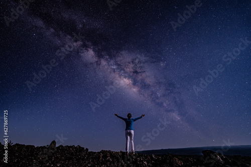 Woman on the Milky Way. Stargazing at Mauna Loa Observatory Road, Big Island Hawaii. Starry night sky, galaxy astrophotography. 