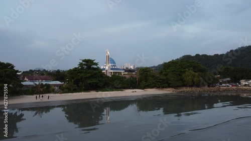 Serene lake coastal with a mosque at background of Permatang Damar Laut photo