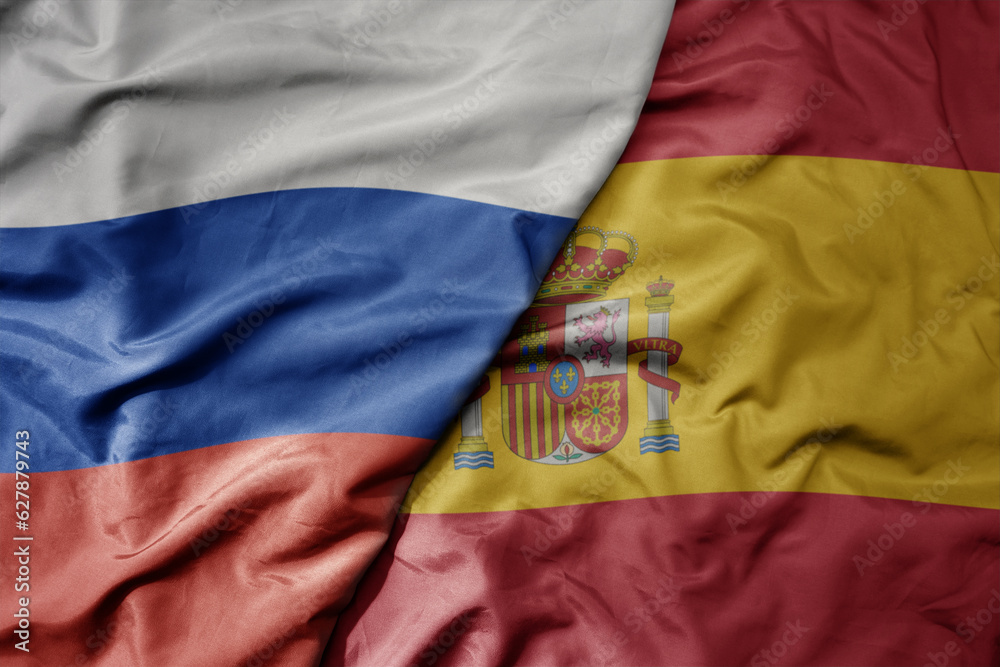 Fototapeta premium big waving realistic national colorful flag of russia and national flag of spain .