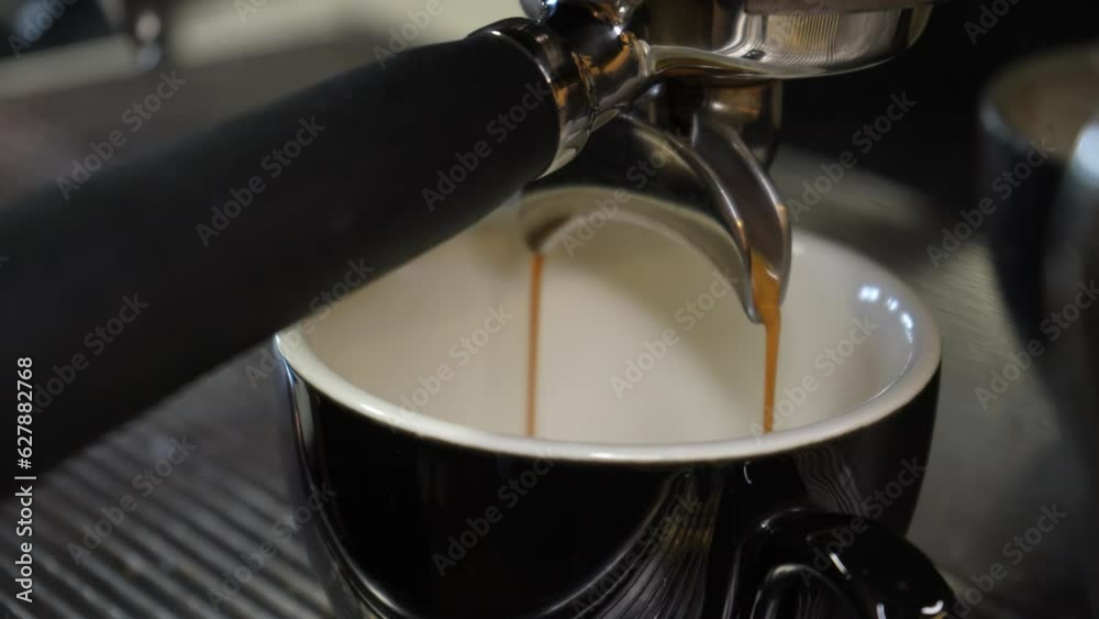 Video coffee flows from the machine into the cup. Homemade hot espresso. Freshly ground coffee flows. A barista prepares coffee in a cafe. Video coffee flows from the machine into the cup. Homemade hot espresso. Freshly ground coffee flows. A barista prepares coffee in a cafe.