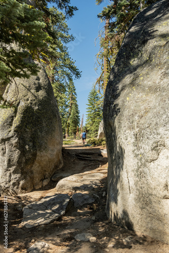 Woman Hikes on Trail Through Large Boulders in Yosemite