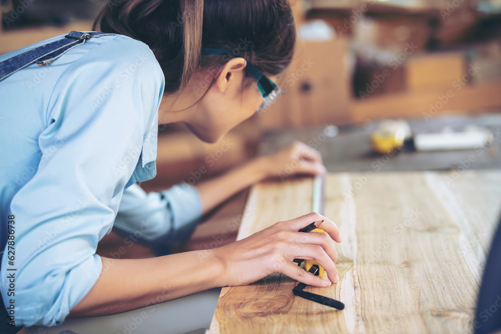 Attractive middle aged woman carpenter designer works with ruler, make notches on the tree in workshop. Image of modern femininity. Concept of professionally motivated women Attractive middle aged woman carpenter designer works with ruler, make notches on the tree in workshop. Image of modern femininity. Concept of professionally motivated women