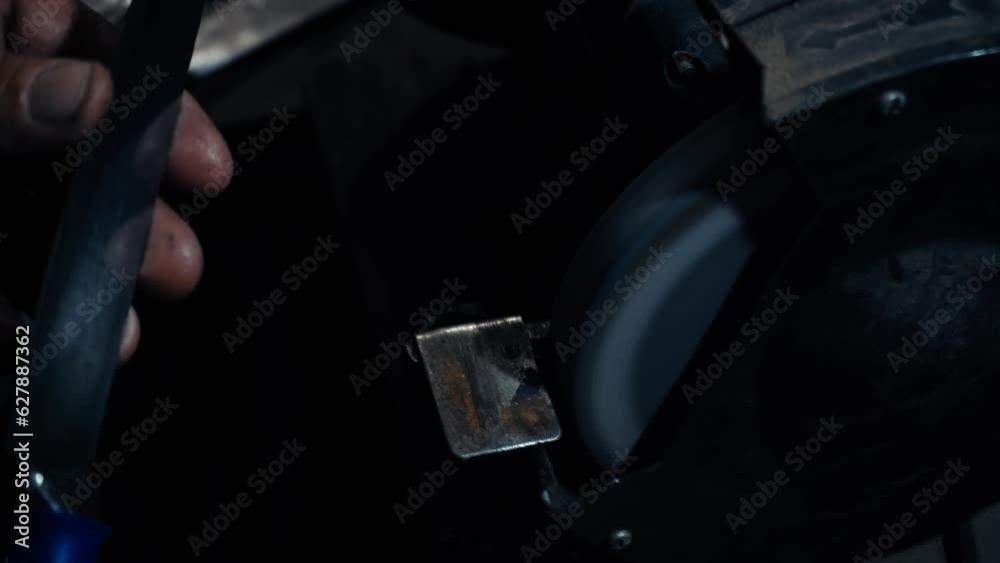 Grinding work with smooth equipment for steel metal, iron. Close-up of sparks in the workshop. Processing tools on a grinding machine.