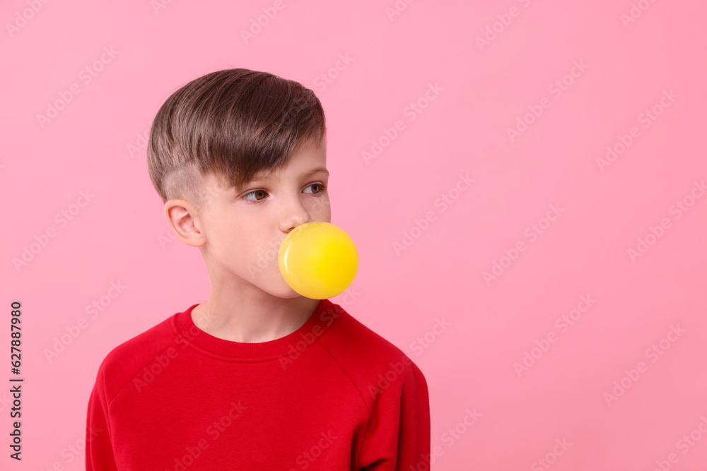 Boy blowing bubble gum on pink background, space for text Boy blowing bubble gum on pink background, space for text