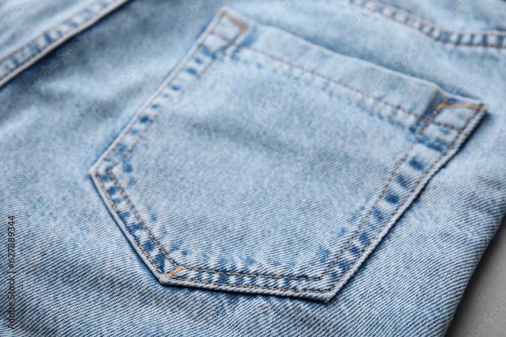 Jeans with pocket on grey background, closeup Jeans with pocket on grey background, closeup