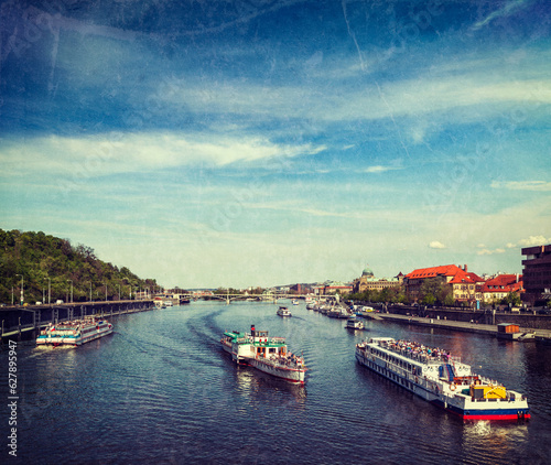 Vintage retro hipster style travel image of turist boats on Vltava river in Prague, Czech Republic with grunge texture overlaid