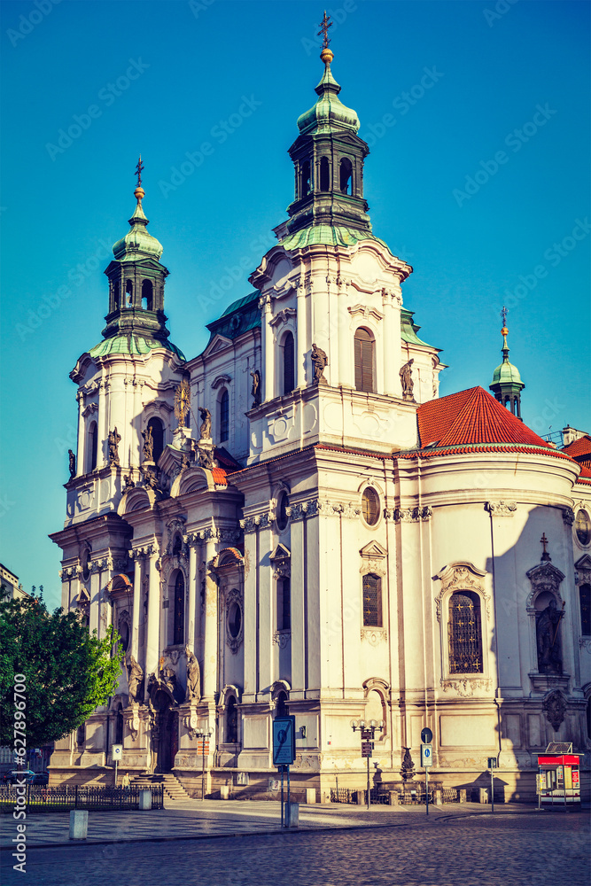Vintage retro hipster style travel image of St. Nicholas church at Old Town Square early in morning, Prague, Czech republic