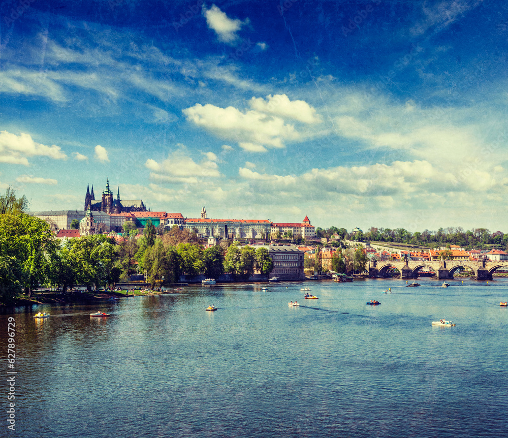 Vltava river and Gradchany (Prague Castle) and St. Vitus Cathedral and Charles bridge an people in paddle boats in the Prague, Czech Republic with grunge texture overlaid