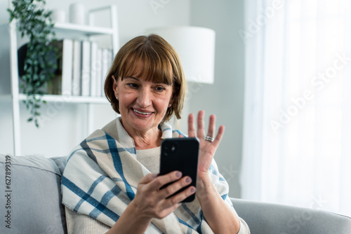 Caucasian senior woman smile and video call in living room at home. 