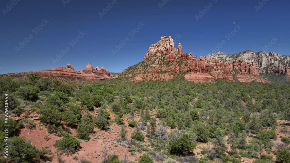 Aerial over landscape with trees toward striking red rock formations of Sedona Aerial over landscape with trees toward striking red rock formations of Sedona