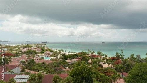 Antigua and Barbuda - 2023: aerial view beautiful caribbean island coastline panorama with villa houses and sandy beach with boats on shore. Famous travel destination in Caribbeans photo