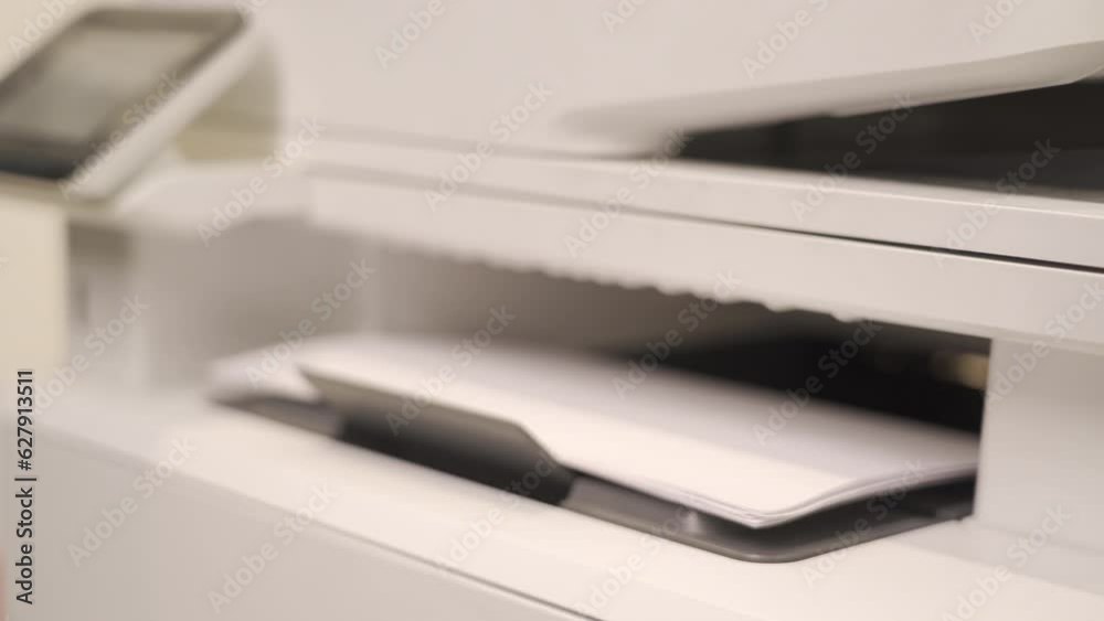 The office printer is working, white sheets come out of the printer, close-up The office printer is working, white sheets come out of the printer, close-up