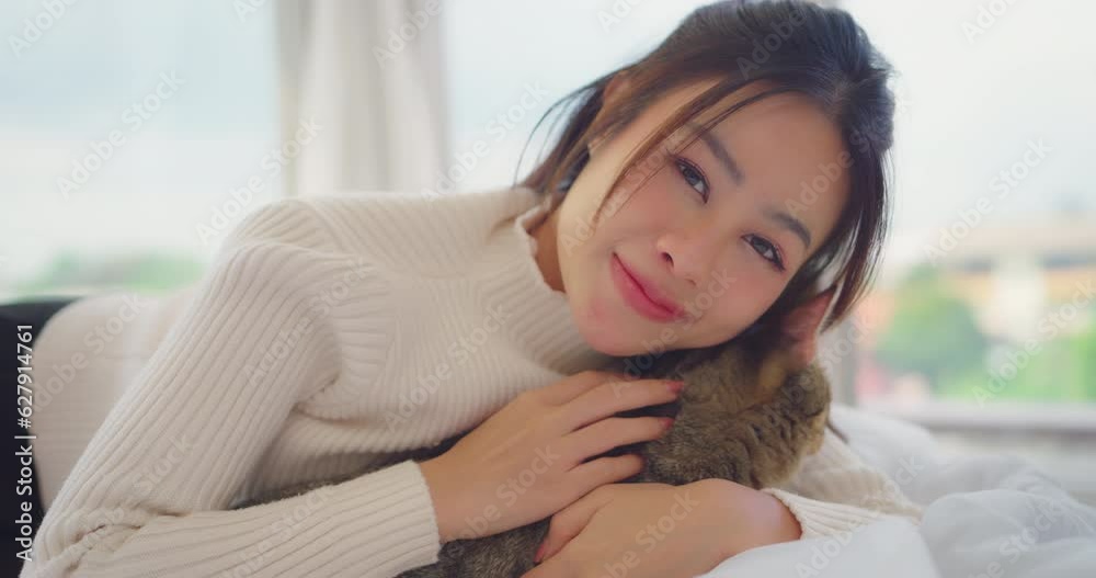 Portrait of young asian woman holding cat with smiling in living room at home. cat look relax and enjoy and woman look happiness to stay and enjoy with her pet. Portrait of young asian woman holding cat with smiling in living room at home. cat look relax and enjoy and woman look happiness to stay and enjoy with her pet.