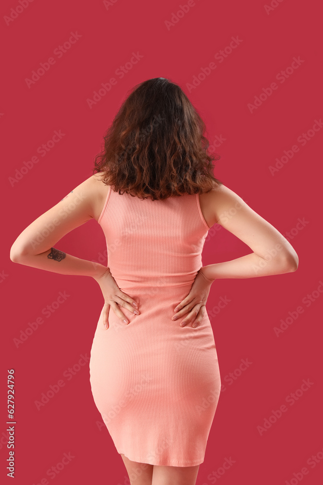 Attractive young woman in dress on pink background, back view Attractive young woman in dress on pink background, back view