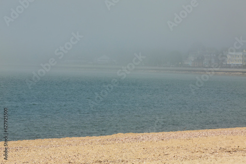 Foggy, sandy, crescent beach on the Connecticut shoreline in Niantic. photo