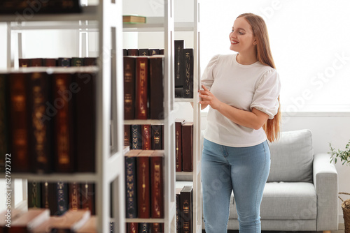 Young woman near bookshelf in library