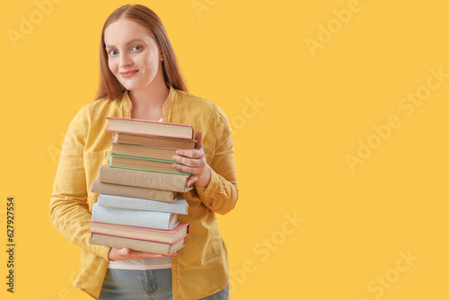 Young woman with stack of b...